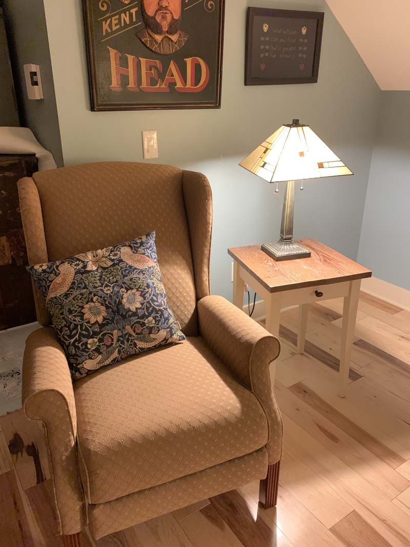 Cozy armchair corner with a stained-glass lamp in the Guest Apartment