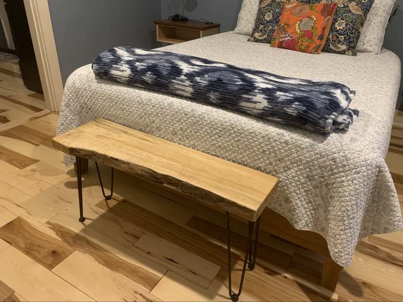 Guest Apartment bedroom — queen bed with a live-edge wooden bench at its foot