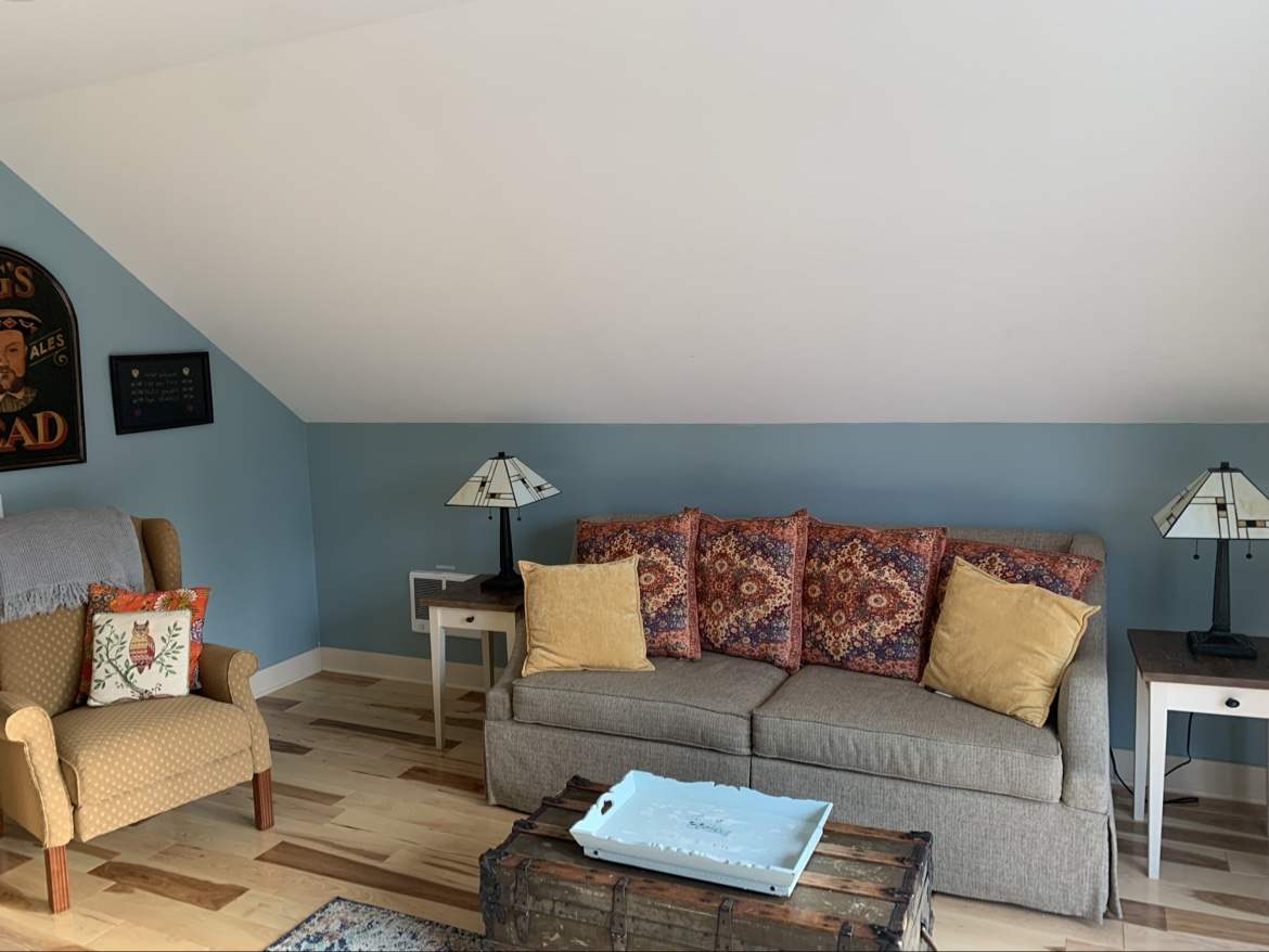 Guest Apartment living room — sofa with colorful pillows, trunk coffee table, and stained-glass lamps