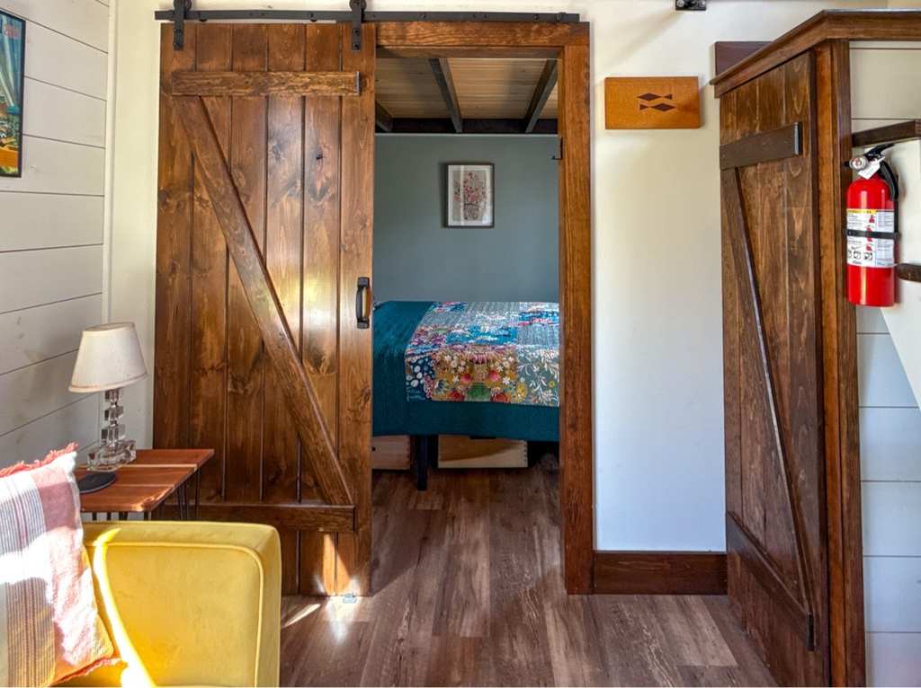 Tiny House interior with sliding barn door to the bedroom